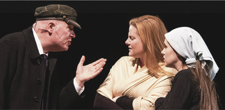Three actors performing a scene from the play